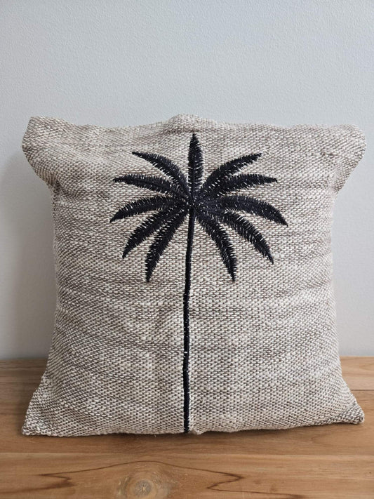Coussin en tissu naturel avec palmier brodé, style bohème pour décoration intérieure.
