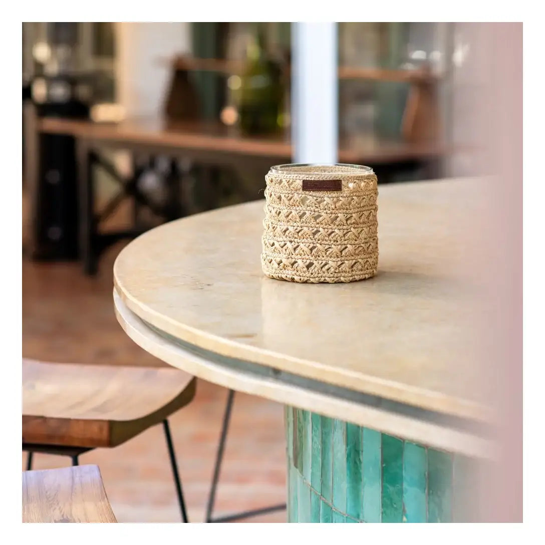 Panier en jute tressée avec motif ajouré, posé sur une table en marbre, style bohème