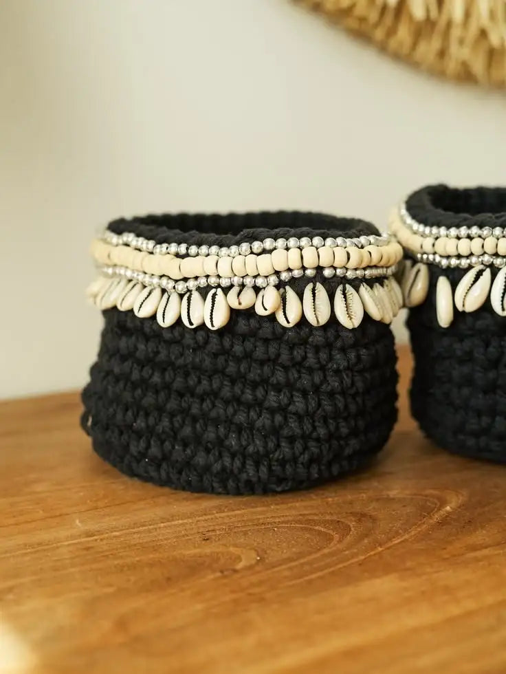 Panier noir tricoté orné de coquillages et perles, style bohème artisanal sur bois