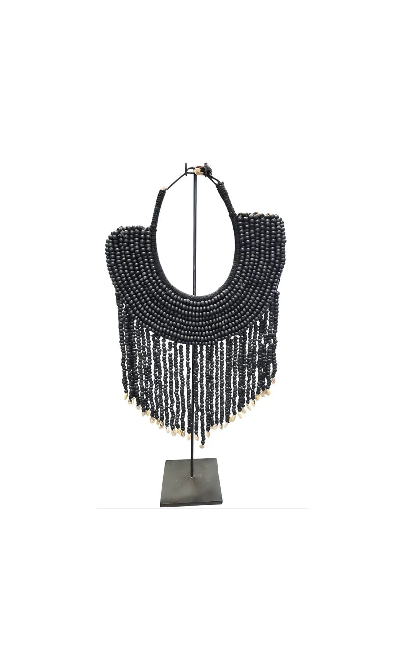 Collier décoratif en coquillages et perles sur socle noir