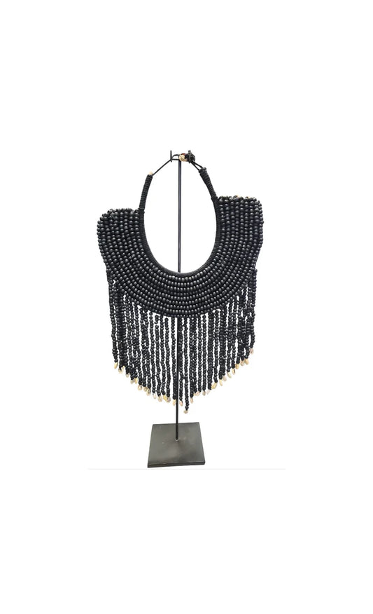 Collier décoratif en coquillages et perles sur socle noir