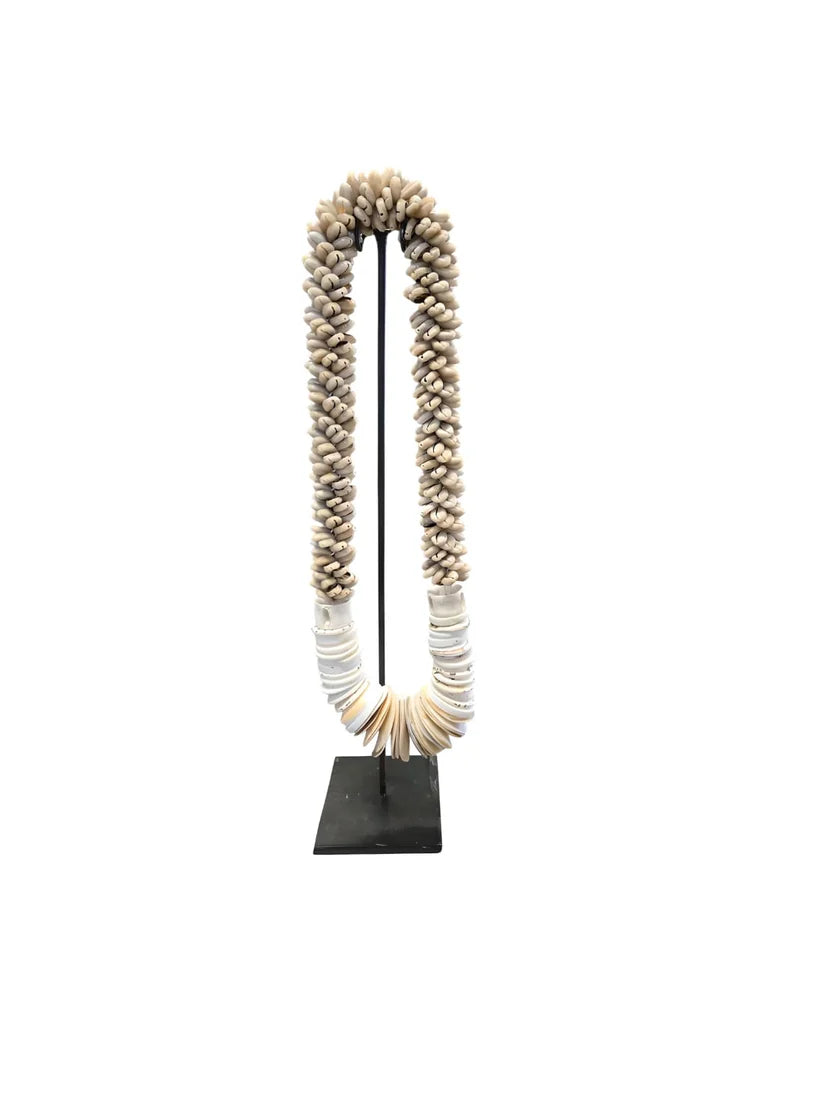 Collier décoratif en coquillages sur socle beige naturel
