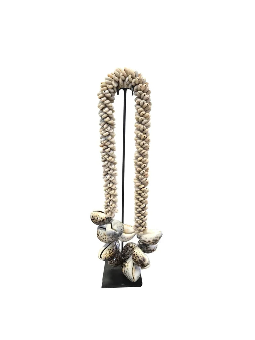 Collier décoratif en coquillages sur socle beige