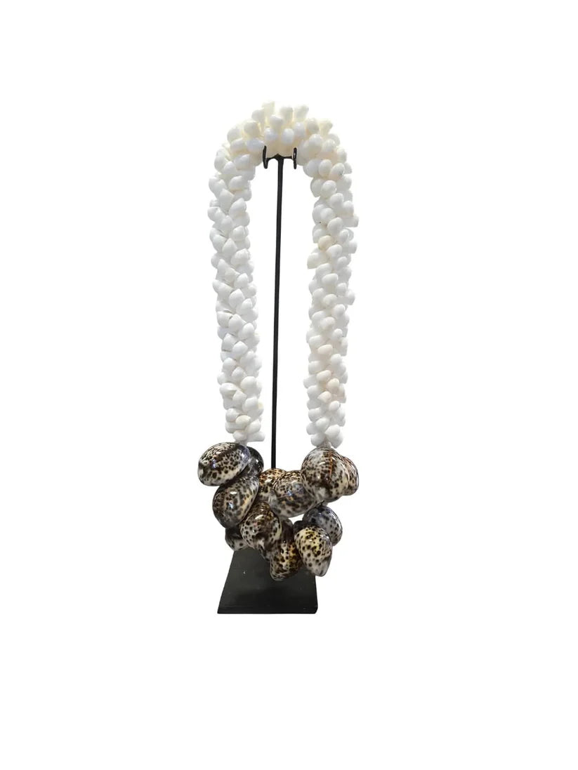Collier décoratif en coquillages sur socle blanc et brun