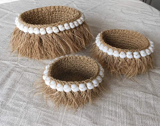 Paniers en fibre naturelle ornés de coquillages blancs, style bohème artisanal pour décoration intérieure.
